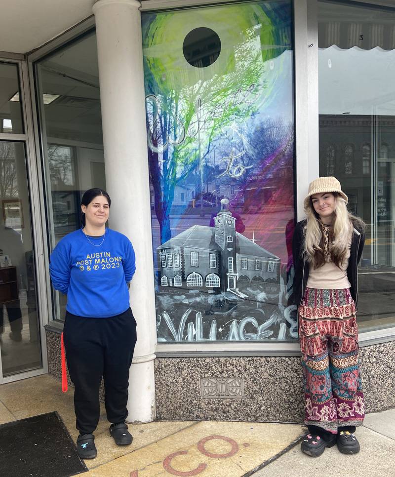 Savanah Freeman standing on the right. She designed the murals