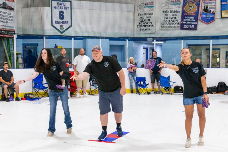 Family members Rachel Diehl, Ian and Kyla Sanfratello, of SGT. Thomas Sanfratello toss out the first throw of the cornhole tournament in his honor  Photo by Steve Ognibene