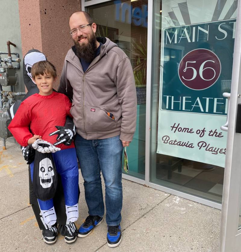 Trick or treater and dad outside theater